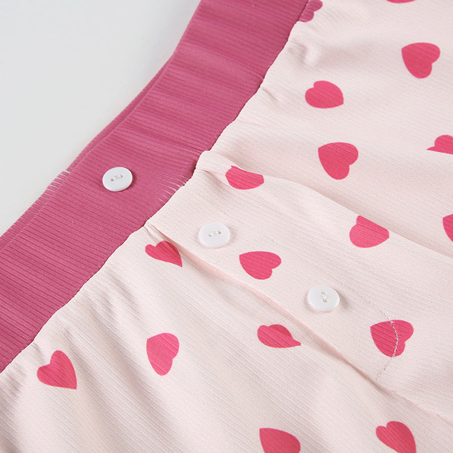 Close-up of the lettuce-edge hem and rib-knit texture of the Costume Inspire heart print pajama top, focusing on the soft pink fabric and red hearts.