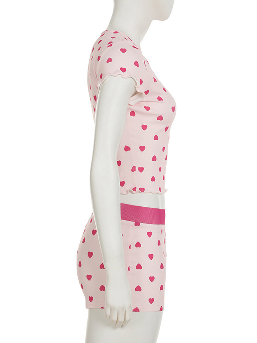 Side view of the All My Love 2-piece pajama set on a mannequin, highlighting the red heart pattern and lettuce-edge trim details on the pink ribbed fabric.