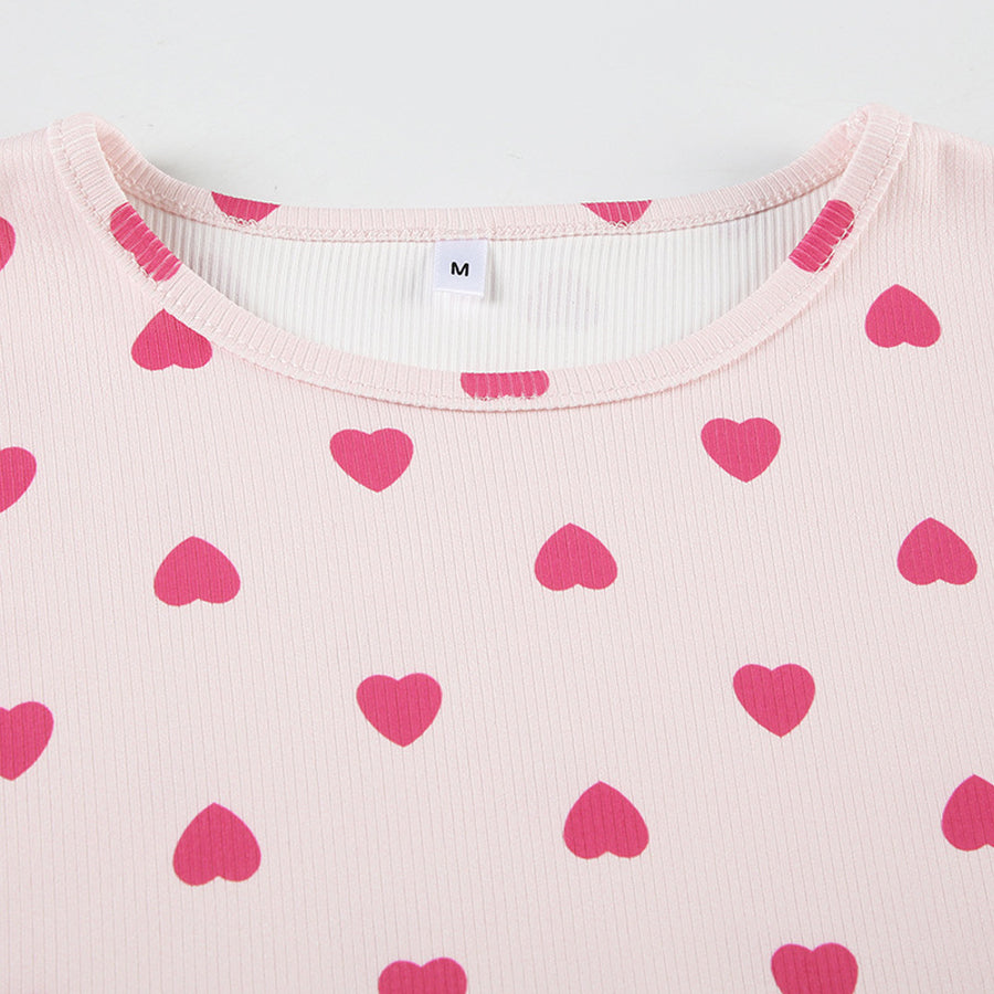 Close-up of the lettuce-edge hem and rib-knit texture of the Costume Inspire heart print pajama top, focusing on the soft pink fabric and red hearts.
