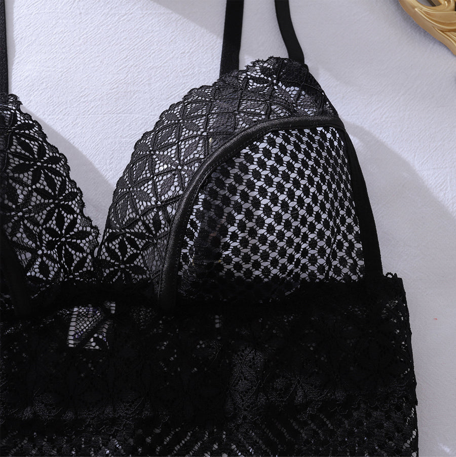 Close-up detail of sheer diamond net mesh fabric and intricate floral lace trim on a sexy black mini dress.